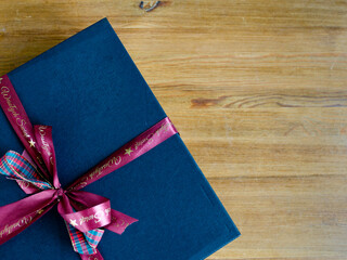 Blue Gift Box With Pink Ribbon On Wooden Surface. Holiday Celebration, Gift Giving