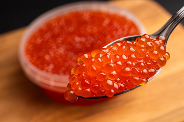 Red Salmon Roe (Ikura) in glass plate on Black Background