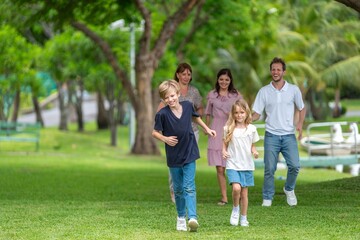Fototapeta premium Happiness family outdoor joyful enjoying nature bonding in nature intergenerational happiness. Multigenerational family walking in park outdoor fun lifestyle relaxing smiling walking connection