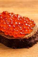 Red Salmon Roe (Ikura) in Plastic Container on Black Background