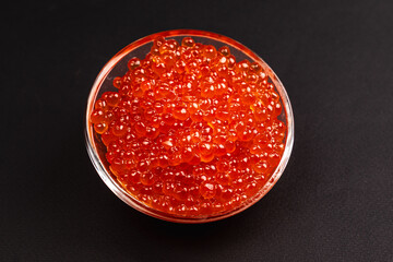 Red Salmon Roe (Ikura) in glass plate on Black Background
