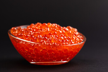 Red Salmon Roe (Ikura) in glass plate on Black Background