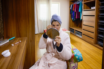 middle-aged woman at home doing her morning cosmetic routine