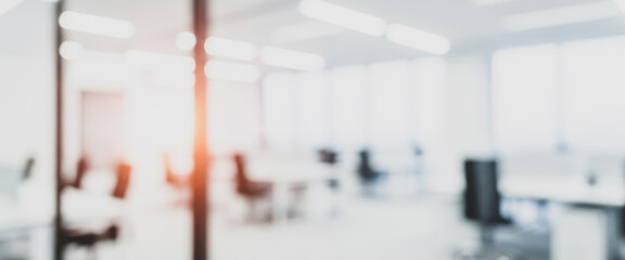 Obraz premium Bright abstract office interior with blurred furniture and light flares, complemented by gentle highlights and soft reflections that create a warm, modern, and visually balanced workplace environment.
