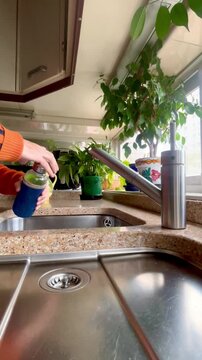 Llenando botella t&eacute;rmica de agua en el fregadero de casa