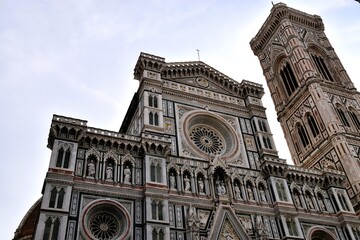 Santa Maria del Fiore Cathedral (Duomo) and Giotto's Campanile in Florence, Italy, displaying magnificent Gothic revival facade and marble patterns.