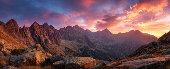 Rugged mountain range illuminated by vibrant sunrise or sunset colors.