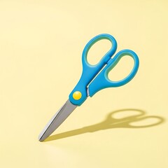Bright blue scissors with yellow accent and shadow on pastel yellow background