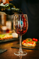 Wine glass with colorful reflections in restaurant scene.wine glass with warm reflections in a restaurant environment. Ideal for wine branding, hospitality marketing and editorial lifestyle photograph