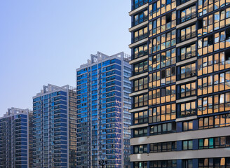 Obraz premium Cityscape on a summer day, modern buildings and houses against the blue sky 