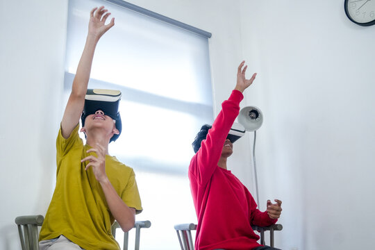 Enthusiastic Teenagers Explore Immersive Virtual Reality Worlds With Headsets On