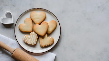 Delicious heart shaped cookies for Valentine's Day baking fun with a rolling pin and cookie cutter