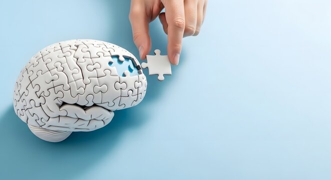 Human hand completing a puzzle brain on a light blue background, symbolizing mental health solution concept, psychological support and cognitive development