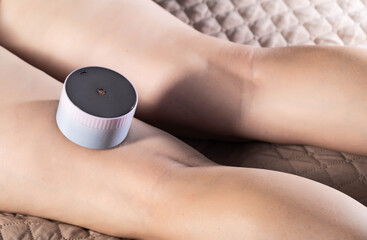 The girl does an anti-cellulite massage on her legs with a portable vacuum massager. Getting rid of flabby skin and cellulite, close-up, effective