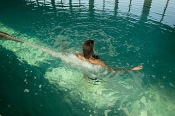Woman relaxing in hydromassage pool with turquoise water