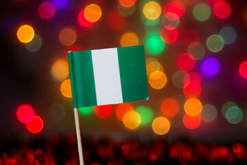 The Nigerian flag against a vibrant, festive bokeh background. Symbolizes Africa's economic giant, Independence Day, and national pride. Excellent for investment, tech, and cultural celebration themes