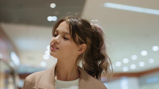 vibrant young portrait, caucasian youth strikes confident pose amidst commercial surroundings, young adult with sprightly demeanor and stylish attire gazes upward with assurance indoors