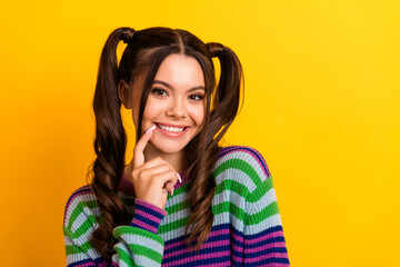 Young woman smiling in striped sweater against a bright yellow background casual fashion portrait