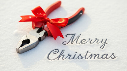 Pliers with red bow on snow background with Merry Christmas text