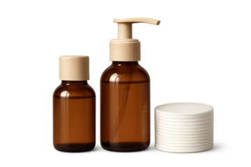 Brown glass cosmetic bottles with pump and stack of white lids