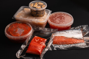 Assorted Seafood Products in Plastic and Vacuum Packaging on Dark Background