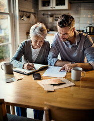 Fototapeta premium Senior Mother and Adult Son Collaborating on Financial Planning at Home