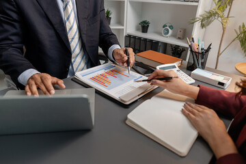 Business professionals reviewing financial charts and performance reports during a meeting, highlighting strategic planning, budget analysis, and teamwork in a modern corporate environment.