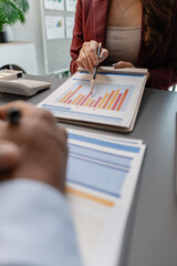 Business professionals reviewing financial charts and performance reports during a meeting, highlighting strategic planning, budget analysis, and teamwork in a modern corporate environment.