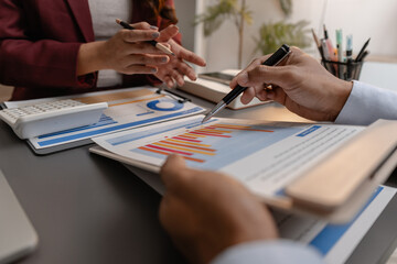 Business professionals reviewing financial charts and performance reports during a meeting, highlighting strategic planning, budget analysis, and teamwork in a modern corporate environment.