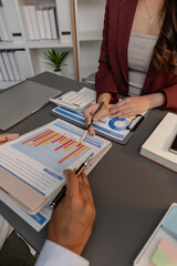 Business professionals reviewing financial charts and performance reports during a meeting, highlighting strategic planning, budget analysis, and teamwork in a modern corporate environment.