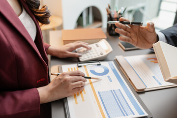 A business meeting scene where professionals review financial charts and exchange insights, highlighting strategic planning and collaborative decision making in a modern office environment.