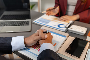 A business meeting scene where professionals review financial charts and exchange insights, highlighting strategic planning and collaborative decision making in a modern office environment.