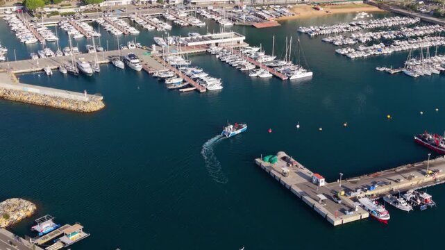 Fishing boat leaving blanes harbor aerial view