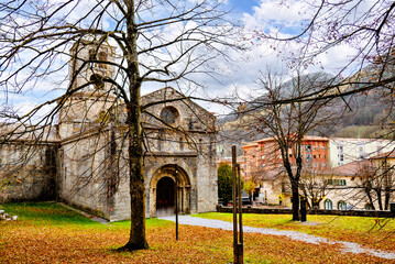 Exterior of the Monastery of Sant Pere de Camprodon in November with autumn leaves	