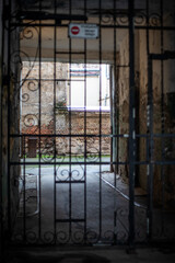 Gated Passageway Leading To Old Brick Courtyard In Weathered Urban Building