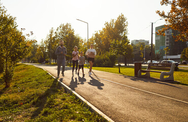 Family with parents and children running together. They run on a sunny urban park track, smiling, keeping a steady jogging pace for fitness and bonding. Symbolizes active family wellness outdoors.