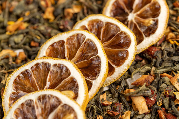 bright large dry lemon slices and tea with pieces of fruit, high-quality green tea with added flavors and pieces of fruit and cut dried yellow lemons