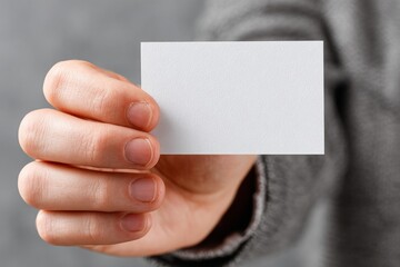 Obraz premium Person presenting a clean textured business card for contact and branding