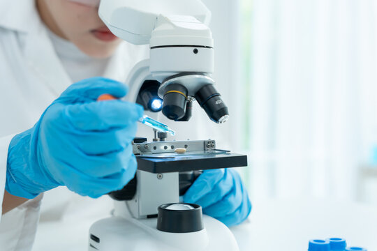 Scientist analyze biochemical samples in advanced scientific laboratory. Medical professional use microscope look microbiological developmental of viral. Biotechnology research in science lab. - Powered by Adobe