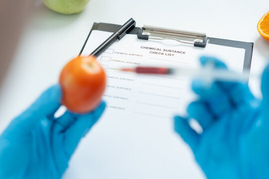 Scientist check chemical food residues in laboratory. Control experts inspect quality of fruit, scientists inject chemicals into apples for experiments, hazards, prohibited substance, contaminate