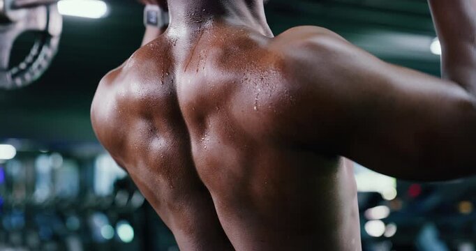 Back, fitness and weightlifting with black man in gym for bodybuilding or strength training. Breathing, exercise and sweating with shirtless bodybuilder or weightlifter in health club for power