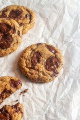 freshly baked homemade chocolate chip cookies on baking paper background