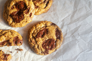 freshly baked homemade chocolate chip cookies on baking paper background