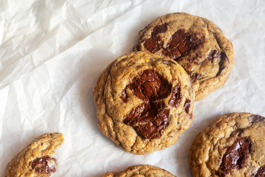 freshly baked homemade chocolate chip cookies on baking paper background