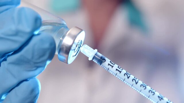 Diabetologist draws medicinal solution into insulin syringe for injection to patient in clinic, treatment and prevention of diabetes