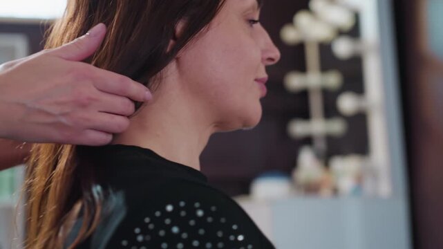 casual image showing woman checking her hair, woman looks at her hair as stylist observes her in portrait, relaxed portrait capturing woman inspecting her hair while stylist watches attentively