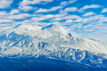 great amazing mountain peak in white winter snow with beautiful blue cloudy sky on background
