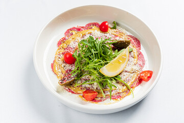 A vibrant dish showcases a colorful blend of fresh ingredients, topped with herbs and lemon