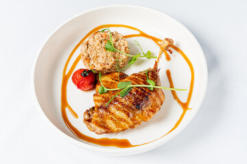Succulent grilled chicken drumstick with rice and cherry tomatoes presented artistically on a plate