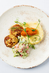 A lovely plate showcases savory meat patties, creamy mashed potatoes, and fresh salad